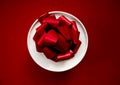 Gift in a white round box with a red bow on a red background. Top view. Royalty Free Stock Photo