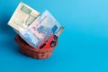 A gift in a wicker basket, money and a car in a hand-woven basket on a blue background
