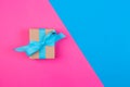 Gift wrapped and decorated with blue bow on colored background with copy space. Flat lay, top view Royalty Free Stock Photo