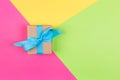 Gift wrapped and decorated with blue bow on colored background with copy space. Flat lay, top view Royalty Free Stock Photo