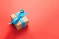 Gift wrapped and decorated with blue bow on orange background with copy space. Flat lay, top view Royalty Free Stock Photo