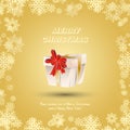 Gift wrapped with gold ribbons and a red bow against the snow. Festive greeting card for Christmas and New Year Royalty Free Stock Photo