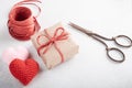 Gift wrapped in paper, scissors, raffia cord, crochet hear. Zero waste celebration concept