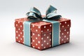 The gift is wrapped in red paper with white polka dots and tied with a blue ribbon. Royalty Free Stock Photo