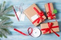 Gift wrapping, gift boxes with tags, ribbon and snow fir tree branch, wooden background, top view Royalty Free Stock Photo