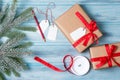 Gift wrapping, gift boxes with tags, ribbon and snow fir tree branch, wooden background, top view Royalty Free Stock Photo