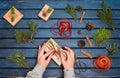 Gift wrapping. Packaging christmas present boxes. Topview of hands with fir tree, cedar, juniper, branches. Preparation for holid