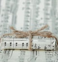 Giftbox on music sheet. A musical gift on notes background