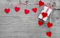 Giftbox wrapped in paper with hearts on a wooden background