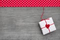 Giftbox wrapped in paper with a red heard on a wooden background