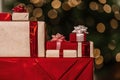 Gifts on the background of a Christmas tree with a bokeh. Royalty Free Stock Photo