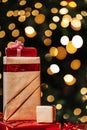 Gifts on the background of a Christmas tree with a bokeh. Royalty Free Stock Photo