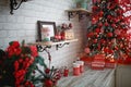 Gifts in boxes close-up under a Christmas tree with red and white decor in a white living room. New year, European style, kitchen