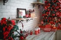 Gifts in boxes close-up under a Christmas tree with red and white decor in a white living room. New year, European style, kitchen