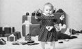 Gifts for child first christmas. Things to do with toddlers at christmas. Little baby girl play near pile of gift boxes