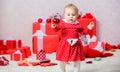 Gifts for child first christmas. Things to do with toddlers at christmas. Little baby girl play near pile of gift boxes