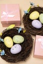 Gifts for Easter, Easter sale. Eggs in nests and gift boxes on a beige background. Royalty Free Stock Photo
