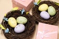 Gifts for Easter, Easter sale. Eggs in nests and gift boxes on a beige background. Royalty Free Stock Photo