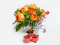 Gifts, flowers in the shopping cart. Buyer`s basket. Grey background. Full shopping cart. The concept of gifts and shopping befor