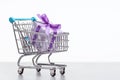 Gifts packed in box wrapped in violet paper polka dot. Shopping cart