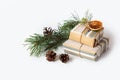 Gifts packed in kraft paper on a white isolated background. Pine branches and cones, dried oranges. Copy space. Christmas