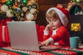 Gifts service. Smart toddler surfing internet. Helper of Santa with a Christmas magic gifts. Christmas. Home. Christmas Royalty Free Stock Photo