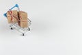 Gifts in a small shopping trolley on a white background, concept, copy space Royalty Free Stock Photo