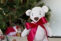 Gifts under the tree for Christmas day. Very cute hand crochet teddy bear with red bow. Christmas background Royalty Free Stock Photo