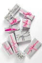 The gifts are wrapped in beautiful gray paper and decorated with silver and pink ribbons. decor in the form of pink feathers and