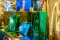 Gifts wrapped in colorful foil, green, blue and gold. Shallow depth of field