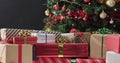Gifts wrapped in festive paper sit in front of a decorated Christmas tree Royalty Free Stock Photo