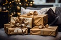 gifts wrapped in gold paper sitting on a couch in front of a christmas tree