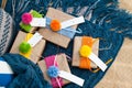 Gifts wrapped in kraft paper lie on a knitted rug. Royalty Free Stock Photo