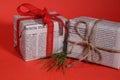 Gifts wrapped in old newspaper on red background