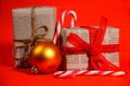 Gifts wrapped in old newspaper on red background