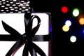 Gifts wrapped with white paper on black background with colorful lights Royalty Free Stock Photo