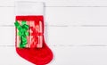 Giftwrapped Presents lying on Christmas Stocking on White Wooden Table Royalty Free Stock Photo