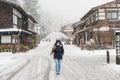 Female tourist holding transparent umbrella and walking on the street with background of Shirakawa-go village