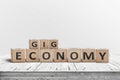 Gig economy sign made of wood on a worn table