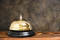 Gilded bell hotel service background concrete wall.Conceptual hotel, travel and recreation