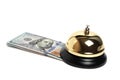 Gilded bell hotel service and hundred dollar bills white background.Conceptual hotel, travel and recreation