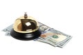 Gilded bell hotel service and hundred dollar bills white background.Conceptual hotel, travel and recreation