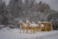The gilded carriage harnessed by four horses, covered with snow