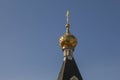 Gilded dome of an Orthodox church with a cross against the sky