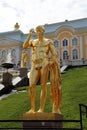 Gilded figure of a man on the background of the Peterhof Palace on a clear sunny day, Peterhof.