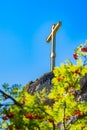 A gilded peasant Orthodox cross stands on top of a cliff