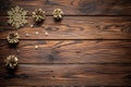 Gilded pine cones, metal stars and sparkling snowflake Christmas ornament on the dark brown plank wooden surface