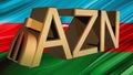 Gilded symbol of AZN manat against the background of the flag of Azerbaijan. Finance concept.