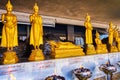 The gilden sculptures of Buddha in small Altar with burning oil lamps, San Lak Mueang shrine in Bangkok, Thailand