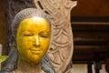 Gilding on the face of wooden female sculpture